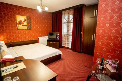 a hotel room with a bed and a television at Globus Hotel in Plovdiv