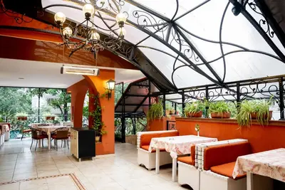 a restaurant with tables and chairs and plants at Globus Hotel in Plovdiv