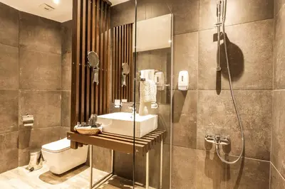a bathroom with a sink and a shower and a toilet at Hotel Orlovetz in Pamporovo