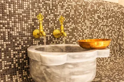 a bath tub with a wooden bowl in a bathroom at Hotel Orlovetz in Pamporovo