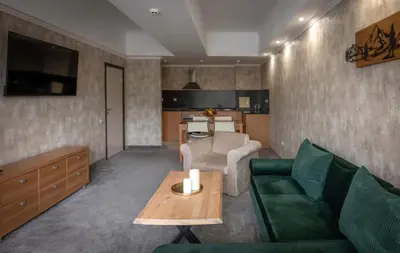 a living room with a green couch and a table at Snezhanka Hotel Pamporovo - Half Board & Swimming pool in Pamporovo
