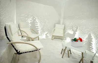 two chairs and a table in a room with snow at Rhodopi Home Hotel Chepelare- Half Board & Wellness in Chepelare