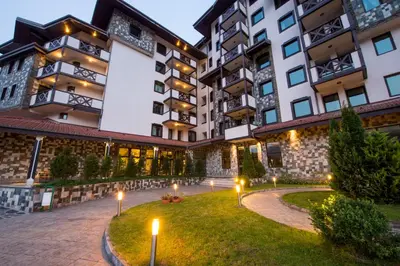 a courtyard in a building with lights in the grass at Rhodopi Home Hotel Chepelare- Half Board & Wellness in Chepelare