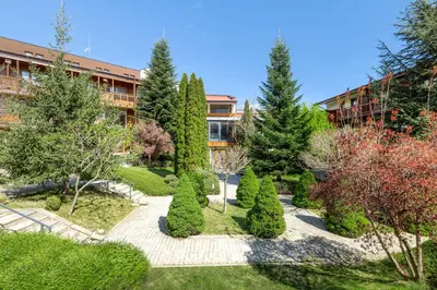 a garden in front of a building with trees at Four Points by Sheraton Bansko in Bansko