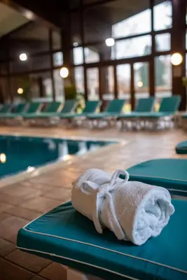 a towel sitting on a table next to a swimming pool at Hotel Pirin SKI & SPA in Bansko