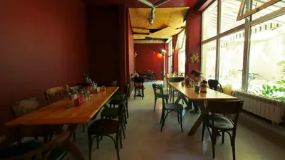 a restaurant with wooden tables and chairs in a room at Hotel Alabin Central in Sofia
