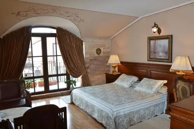 a bedroom with a bed and a large window at Boutique Hotel Boris Palace & Restaurant in Plovdiv