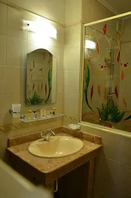 a bathroom with a sink and a painting on the wall at Boutique Hotel Boris Palace & Restaurant in Plovdiv