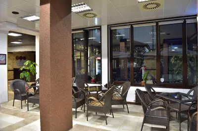 a restaurant with chairs and tables and windows at Royal Bansko Family Apart Hotel - All Inclusive Light or Half Board & Drinks With Heated Indoor Pool & Jacuzzis in Bansko
