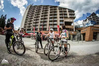 a group of people riding bikes in front of a building at Rila Hotel Borovets in Borovets