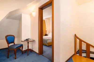 a room with a table and a chair and a mirror at Festa Winter Palace Hotel in Borovets
