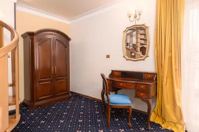 a room with a desk and a wooden cabinet at Festa Winter Palace Hotel in Borovets