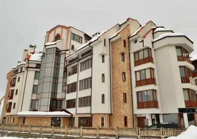 a large apartment building with snow on it at Pirin Place Bansko in Bansko