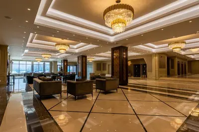 a lobby of a hotel with chairs and a chandelier at Astoria Grand Hotel in Sofia