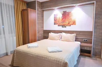 a bedroom with a large bed with two towels on it at Hotel Rothmans-Breakfast - Free parking - Lobby in Bansko