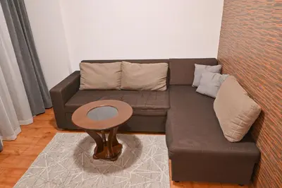 a living room with a brown couch and a table at Hotel Rothmans-Breakfast - Free parking - Lobby in Bansko