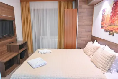 a bedroom with a bed with two towels on it at Hotel Rothmans-Breakfast - Free parking - Lobby in Bansko