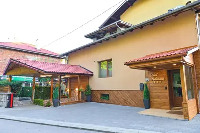 a building with a parking lot in front of it at Hotel Rothmans-Breakfast - Free parking - Lobby in Bansko