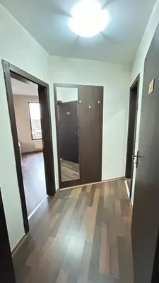an empty room with a hallway with doors and wood floors at Aparthotel Aspen in Bansko
