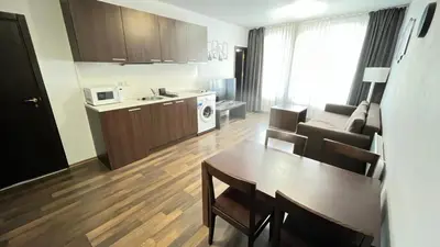 a small living room with a table and a kitchen at Aparthotel Aspen in Bansko