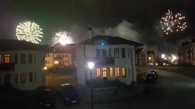 a white house with fireworks in the background at Pinerose Resort in Bansko
