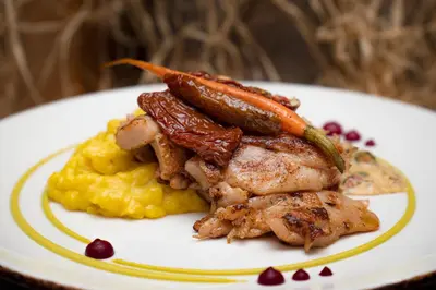 a plate of food with meat and carrots and potatoes at MPM Hotel Sport Ski-in, Ski-out in Bansko