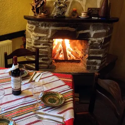 a bottle of wine sitting on a table with a fireplace at Family Hotel Santo Bansko in Bansko