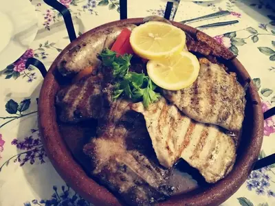 a plate of food with meat and lemon slices at Family Hotel Santo Bansko in Bansko
