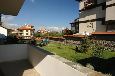 a view of a yard of a house with a garden at Winslow Elegance Apartments in Bansko