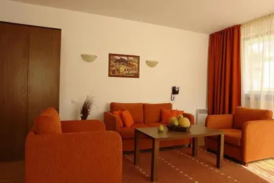 a living room with two orange couches and a table at Winslow Elegance Apartments in Bansko