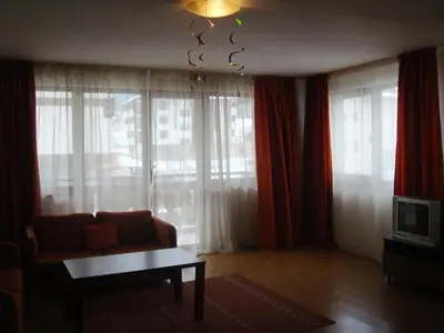 a living room with a couch and a chandelier at Winslow Elegance Apartments in Bansko