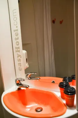 a bathroom with an orange sink and a mirror at easyHotel Sofia in Sofia