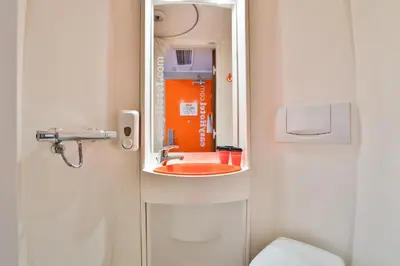 a bathroom with a red sink and a mirror at easyHotel Sofia in Sofia