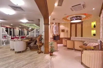 a restaurant with tables and chairs in a room at Hotel Club Central in Hisarya