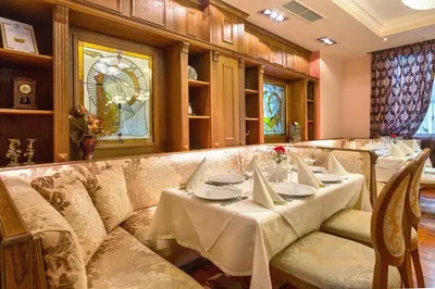 a restaurant with a long couch and a table at Hotel Club Central in Hisarya