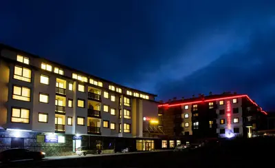 two buildings at night with red lights on them at Hotel Casa Karina Bansko - Half Board & All Inclusive in Bansko