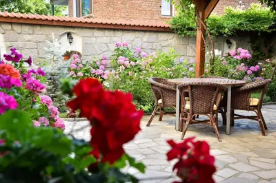 a patio with a table and chairs and flowers at Lina Hotel in Bansko