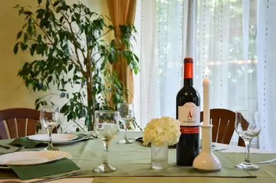 a bottle of wine sitting on a table with glasses at Lina Hotel in Bansko