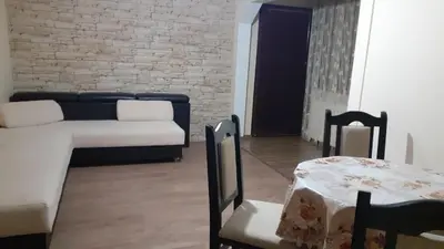 a living room with a couch and a table and chairs at Guesthouse Dida in Sapareva Banya