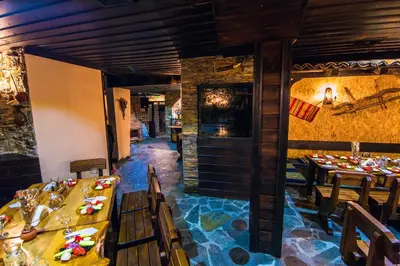 a restaurant with tables and chairs in a room at Family hotel Valchanovata Kashta in Fotinovo