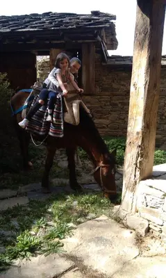 two children riding on the back of a horse at Кюповата къща 1860 Qpova house in Kovachevitsa