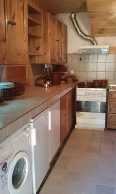 a kitchen with a washing machine and a stove at Кюповата къща 1860 Qpova house in Kovachevitsa