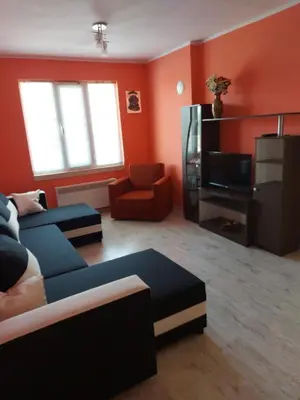 a living room with a blue couch and a tv at Viktoria House in Sapareva Banya