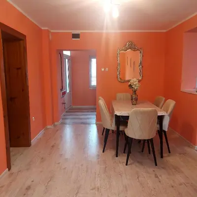 a dining room with orange walls and a table and chairs at Viktoria House in Sapareva Banya
