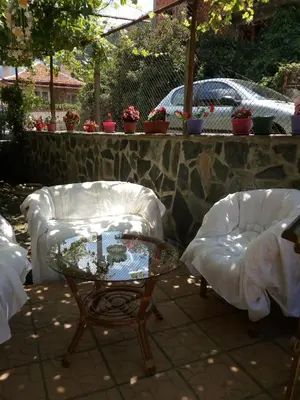 a patio with two chairs and a glass table at Viktoria House in Sapareva Banya