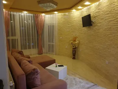a living room with a couch and a tv on a brick wall at Safi in Dospat