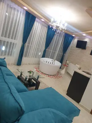 a living room with a blue couch and a bath tub at Safi in Dospat