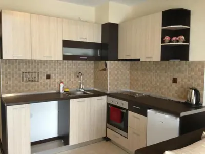 a kitchen with white cabinets and black counter tops at Apartments Hristovi in Sandanski