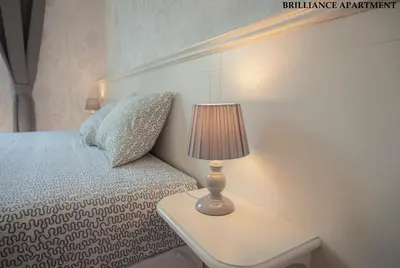 a bedroom with a bed and a lamp on a table at Presidency House Self Check-in Apartments in Sofia