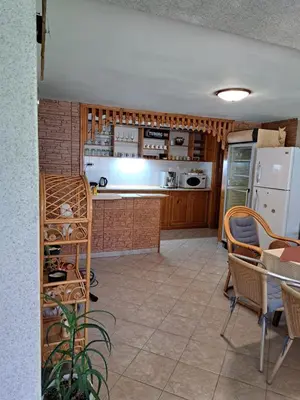a kitchen with a refrigerator and a table and chairs at Guest House Benita in Devin